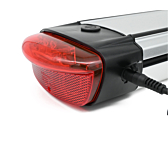 Le chargeur de la batterie compatible Gazelle Innergy Gold est branché sur le côté de la batterie. Le feu arrière est clairement visible.